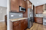 This stunning kitchen boasts rich, dark wood cabinetry and sleek stainless steel appliances, creating a warm and inviting atmosphere.