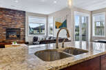 This stunning kitchen boasts a beautiful granite countertop and a modern stainless steel sink, perfect for culinary enthusiasts.