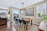 This stunning dining room features a modern aesthetic with a beautiful wooden dining table and stylish black chairs.