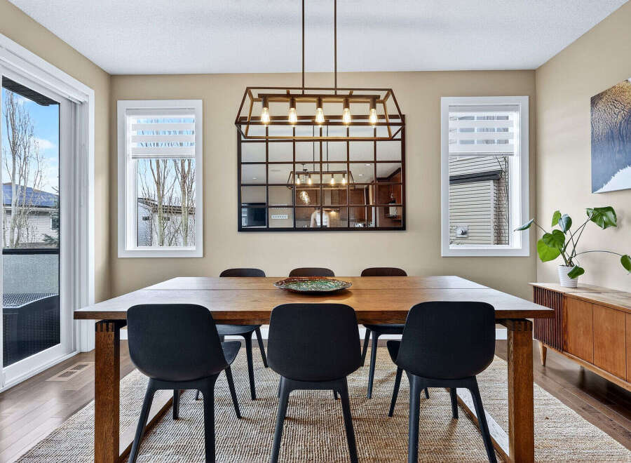 This stunning dining room features a modern aesthetic with a large wooden dining table and sleek black chairs.