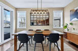 This stunning dining room features a modern aesthetic with a large wooden dining table and sleek black chairs.