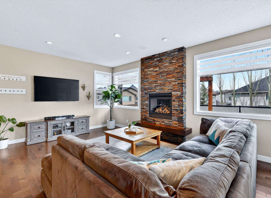 Step into luxury with this stunning living room, featuring a cozy fireplace and a spacious, comfortable sofa.