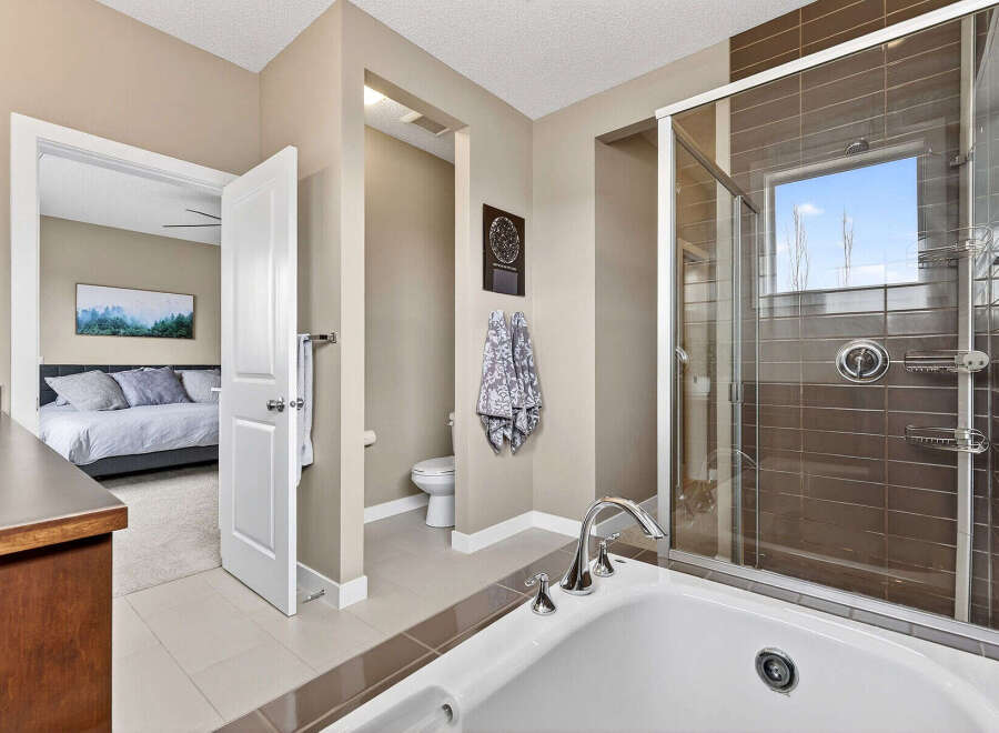 Step into luxury with this stunning bathroom, featuring a sleek glass shower and a relaxing bathtub.