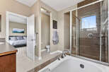 Step into luxury with this stunning bathroom, featuring a sleek glass shower and a relaxing bathtub.