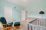 This charming nursery features a serene atmosphere with its light blue walls and a cozy rocking chair.