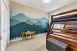 This charming bedroom features a unique mountain-themed mural, creating a serene and playful atmosphere.