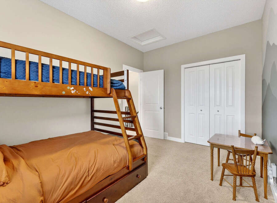 This charming bedroom features a cozy bunk bed, perfect for kids or guests.