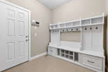 This entryway boasts a custom-built white storage unit, perfect for organizing coats, shoes, and accessories.