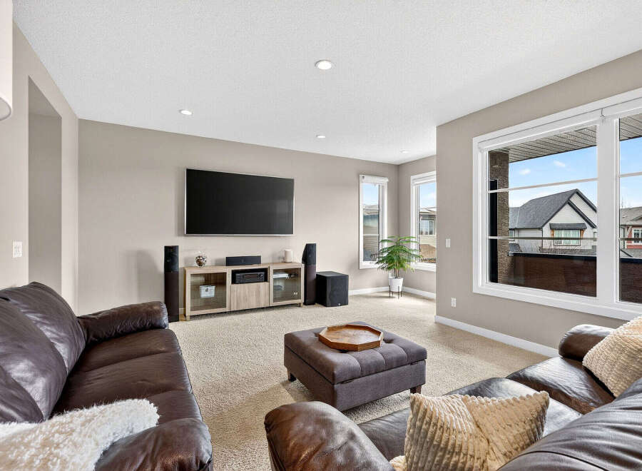 Step into luxury with this stunning living room! Featuring a large flat-screen TV, a cozy leather sofa, and a stylish ottoman, this space is perfect for relaxation and entertainment.
