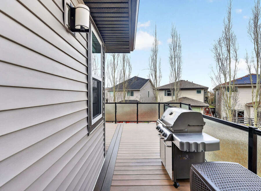 Enjoy outdoor living at its finest with this stunning property featuring a spacious deck and a built-in grill, perfect for entertaining.