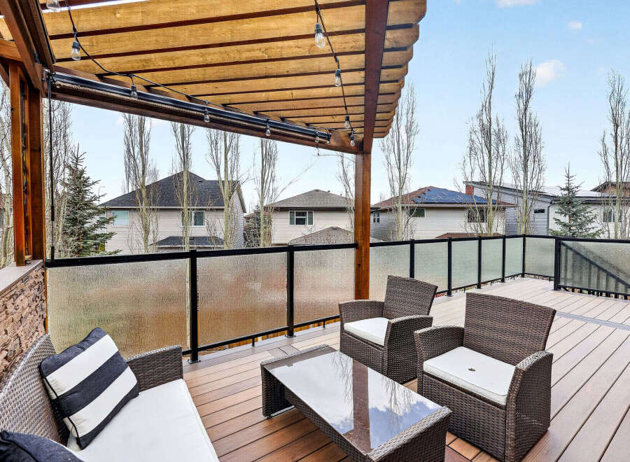 Enjoy outdoor living at its finest with this stunning deck! Featuring a stylish pergola, comfortable seating, and a glass railing, this space is perfect for entertaining or relaxing.
