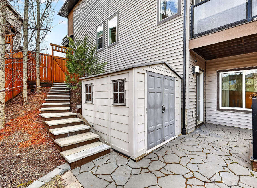 This charming property boasts a well-maintained exterior, featuring a stylish shed and a beautifully paved patio.