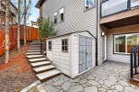This charming property boasts a well-maintained exterior, featuring a stylish shed and a beautifully paved patio.