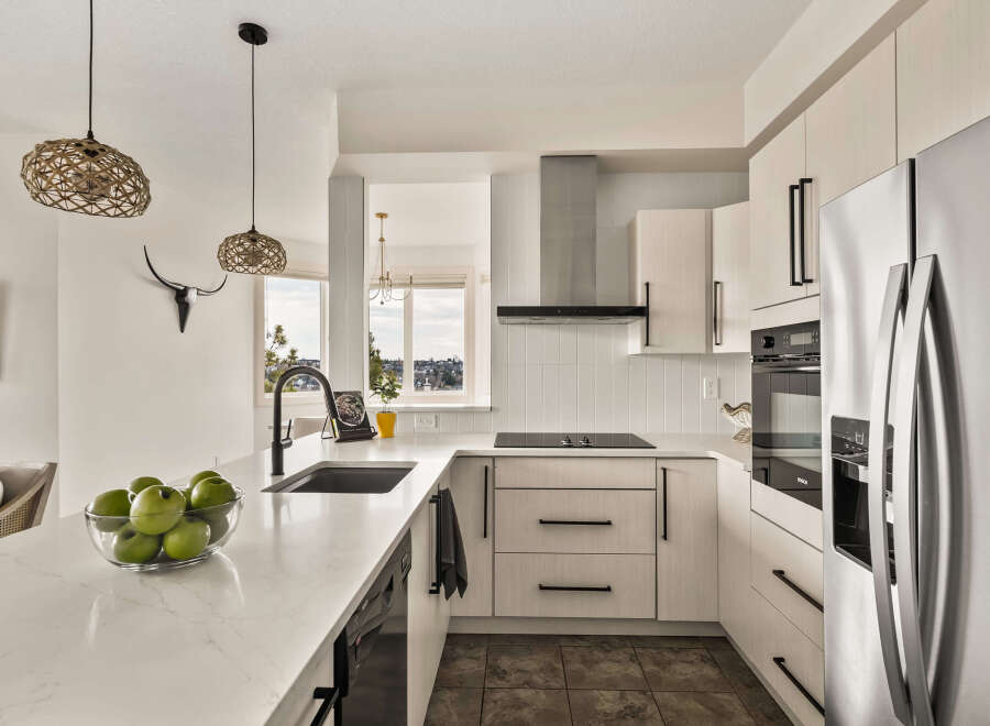 This modern kitchen boasts sleek, white cabinetry and a stunning quartz countertop, creating a bright and inviting space.