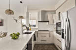 This modern kitchen boasts sleek, white cabinetry and a stunning quartz countertop, creating a bright and inviting space.