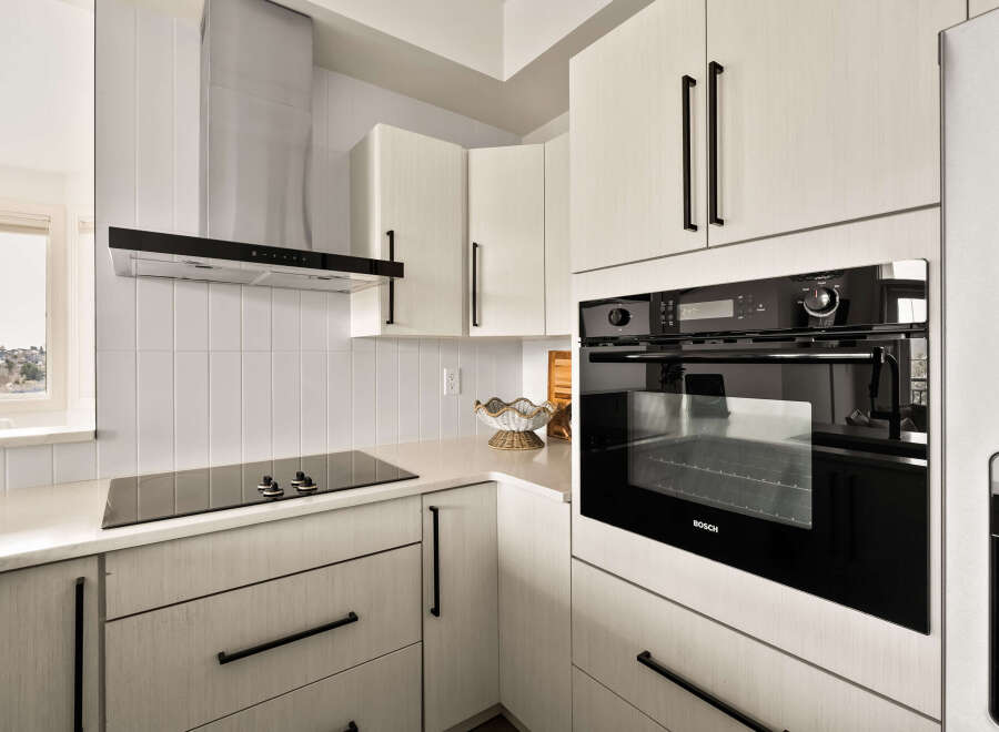 This modern kitchen boasts sleek, white cabinetry and a contemporary design.