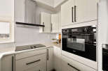 This modern kitchen boasts sleek, white cabinetry and a contemporary design.