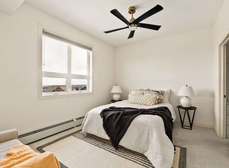 This cozy bedroom offers a serene retreat with its neutral color palette and ample natural light.
