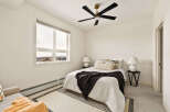This cozy bedroom offers a serene retreat with its neutral color palette and ample natural light.