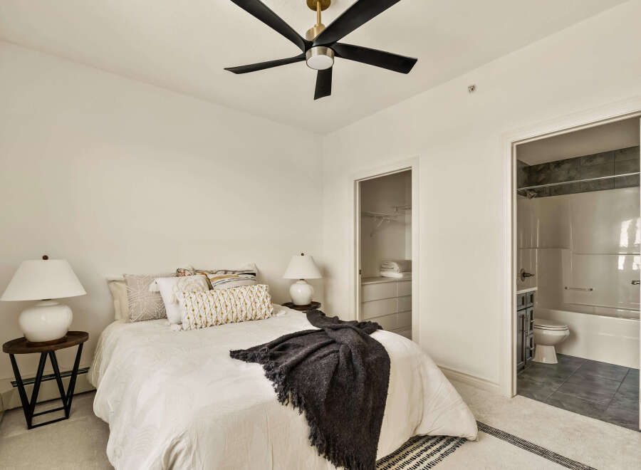Step into this inviting bedroom, featuring a cozy bed adorned with stylish pillows and a soft throw.