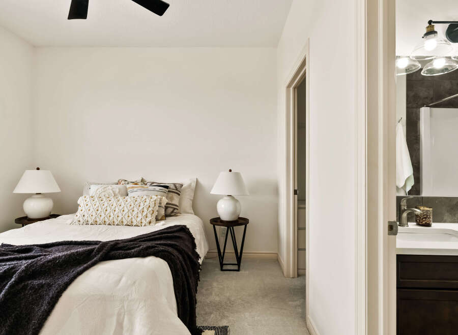 Step into this inviting bedroom, featuring a cozy bed adorned with stylish pillows and a plush throw.