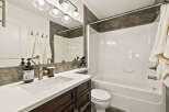 This modern bathroom features a sleek white countertop and dark wood cabinetry, creating a stylish and functional space.