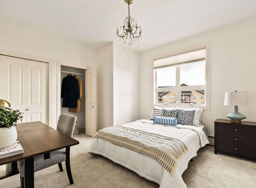 Step into this inviting bedroom, featuring a cozy bed adorned with stylish pillows and a warm throw.