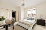 Step into this inviting bedroom, featuring a cozy bed adorned with stylish pillows and a warm throw.