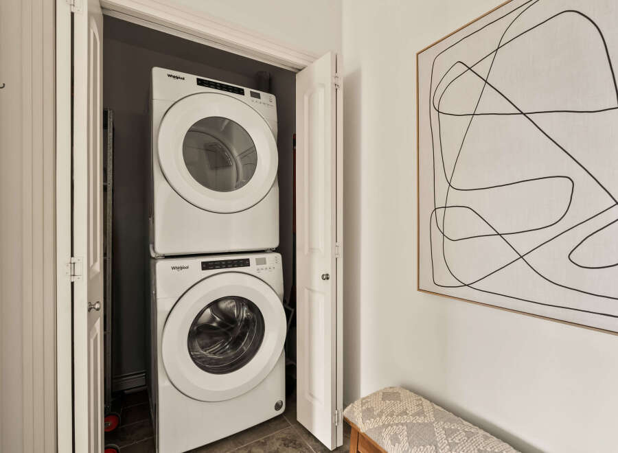 This stunning property boasts a modern laundry area, featuring a stacked Whirlpool washer and dryer for ultimate convenience.