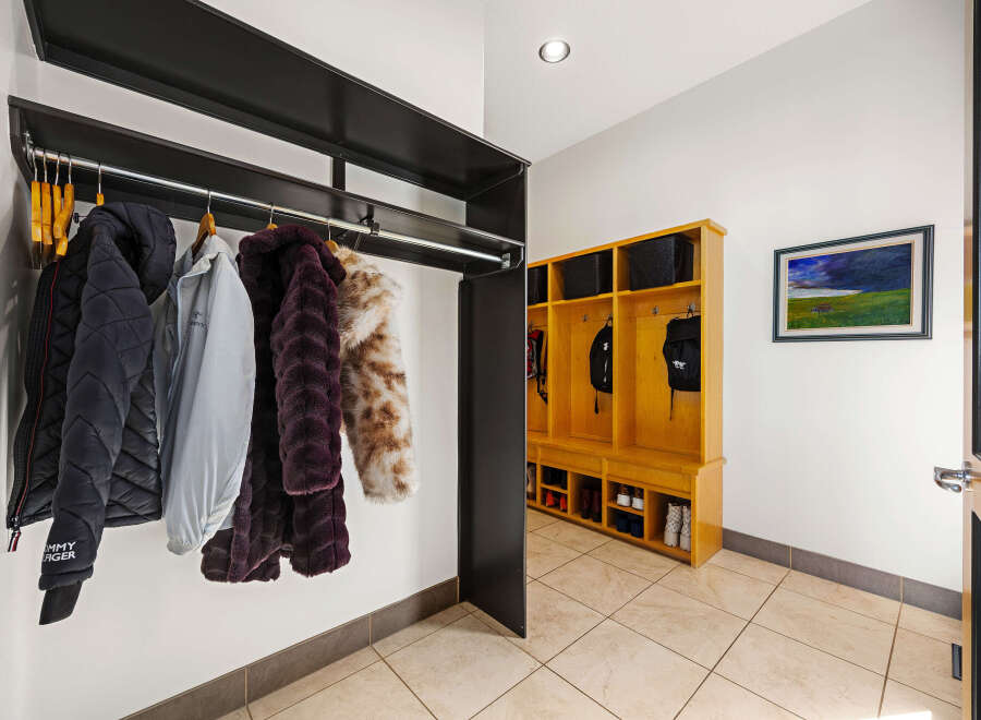 Step into this inviting entryway, showcasing a stylish coat rack and a custom-built storage unit.