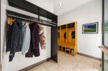 Step into this inviting entryway, showcasing a stylish coat rack and a custom-built storage unit.