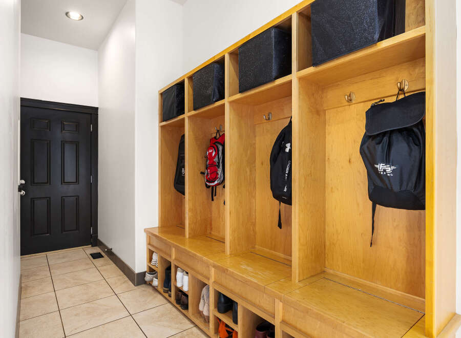 This entryway features a custom-built mudroom with ample storage, perfect for keeping your home organized.