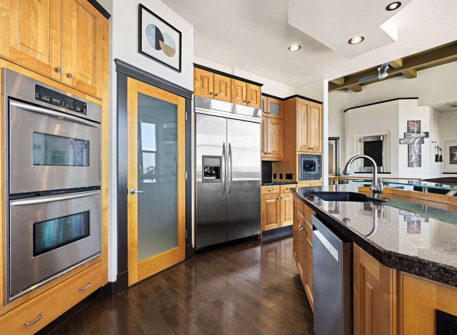 This stunning kitchen boasts modern appliances and elegant wooden cabinetry, perfect for culinary enthusiasts.
