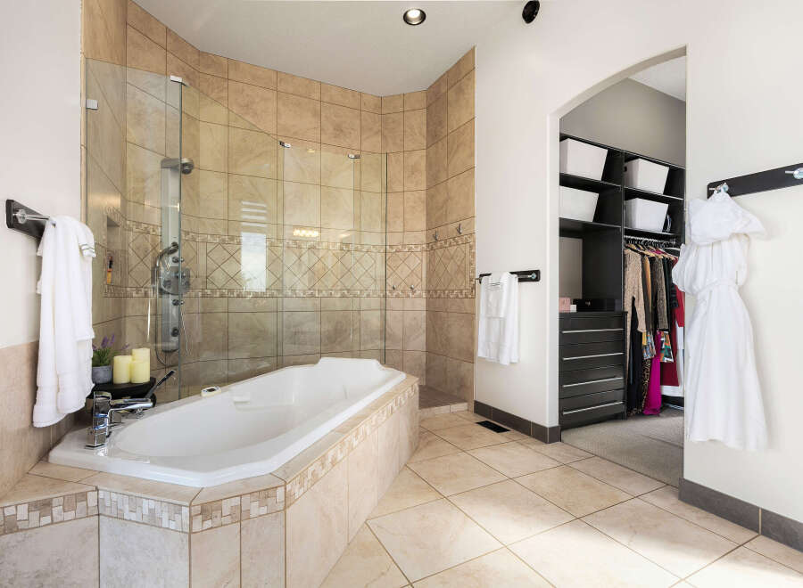 Step into luxury with this stunning bathroom, featuring a spacious soaking tub and a separate glass-enclosed shower.