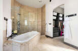 Step into luxury with this stunning bathroom, featuring a spacious soaking tub and a separate glass-enclosed shower.