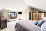 This stunning bedroom boasts a serene ambiance with its neutral color palette and ample natural light.