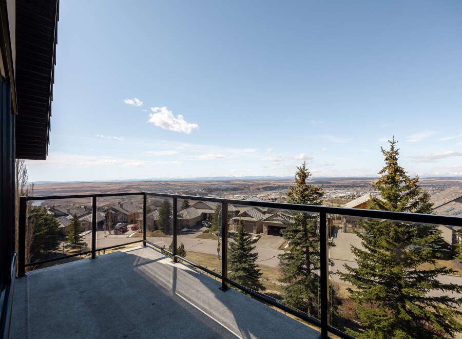 Enjoy breathtaking views from this stunning property! This home features a spacious balcony with glass railings, perfect for taking in the surrounding landscape.