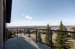 Enjoy breathtaking views from this stunning property! This home features a spacious balcony with glass railings, perfect for taking in the surrounding landscape.