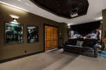 Step into luxury with this stunning home theater! Featuring a star-lit ceiling, comfortable seating, and movie posters, this space is perfect for movie nights.