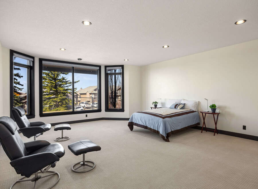 Step into luxury with this stunning bedroom featuring expansive windows that flood the space with natural light.