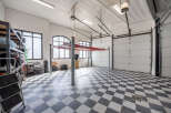 This spacious garage features a two-post car lift, perfect for automotive enthusiasts or professionals.