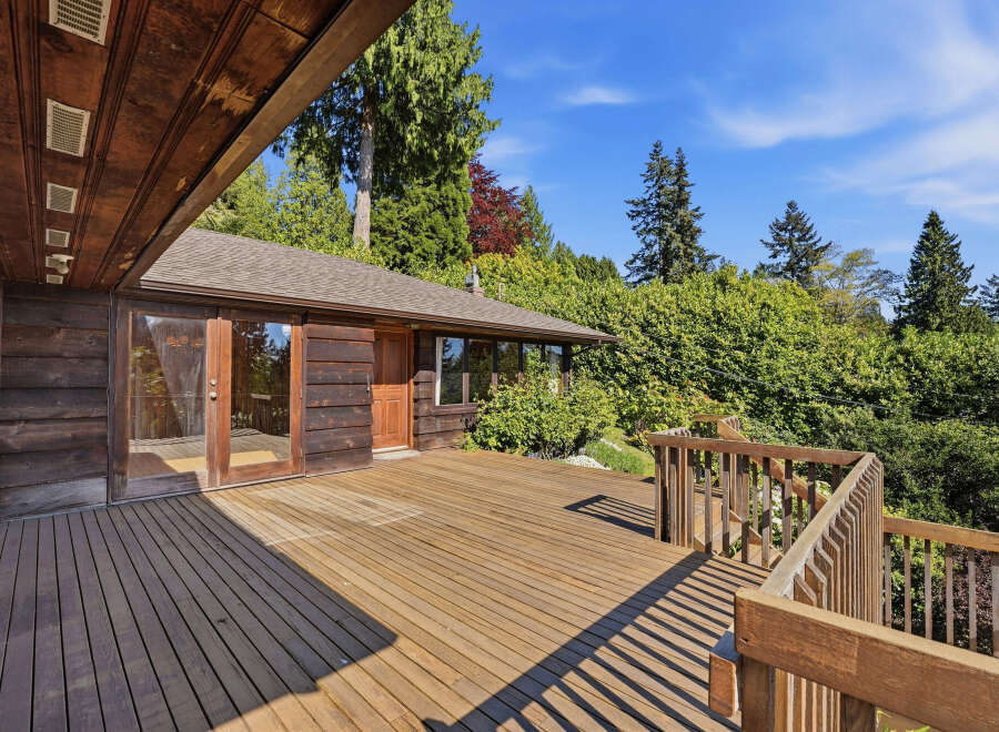 Enjoy the tranquility of this stunning property featuring a spacious wooden deck, perfect for outdoor entertaining and relaxation.