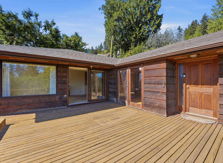 Enjoy the beauty of this stunning property featuring a spacious wooden deck, perfect for outdoor relaxation and entertainment.
