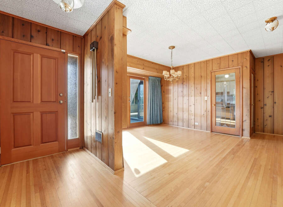 Step into this inviting home featuring beautiful wood paneling and hardwood floors throughout.