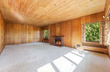 Step into this inviting living space featuring warm wood paneling and a cozy fireplace, perfect for relaxing evenings.