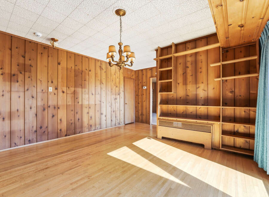 Step into this inviting space, featuring warm wood paneling and a charming chandelier.