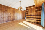 Step into this inviting space, featuring warm wood paneling and a charming chandelier.