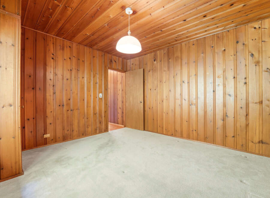 Step into this inviting room featuring warm wood paneling that extends across the walls and ceiling, creating a cozy and rustic ambiance.