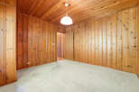 Step into this inviting room featuring warm wood paneling that extends across the walls and ceiling, creating a cozy and rustic ambiance.