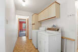 Step into this inviting laundry room, complete with a washer and dryer, and ample storage cabinets.